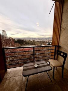a chair and a table on a balcony with a view at Hotel Vera View in Tbilisi City