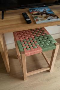 a coffee table with a stool with a remote control on it at Flacalco Hotel & Apartments in Cala Ratjada
