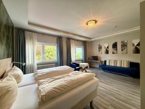 a bedroom with two beds and a living room at Hotel Markgräfler Hof in Badenweiler