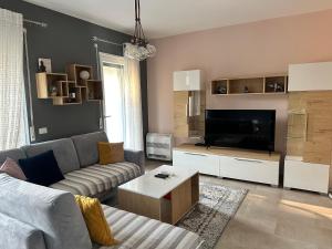 a living room with a couch and a television at White Sand Apartment Valamar 2 Bedroom Balcony Parking in Draç
