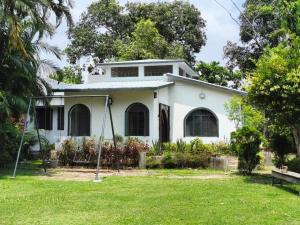 a white house with a green yard at Jairam Eco Villa in Bāruipur