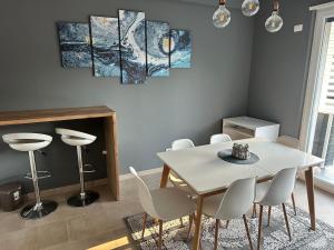 a dining room with a white table and chairs at White Sand Apartment Valamar 2 Bedroom Balcony Parking in Draç