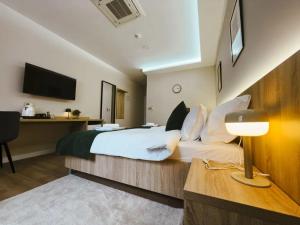 a hotel room with a bed and a desk at Tiona in Nova Gradiška