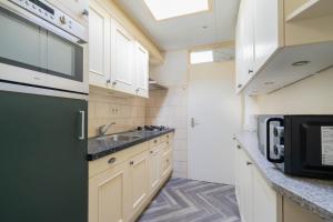 a small kitchen with a sink and a microwave at Bungalowpark Herkingen 1B in Herkingen