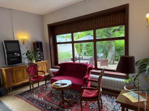 a living room with a couch and a large window at Hotel Markgräfler Hof in Badenweiler