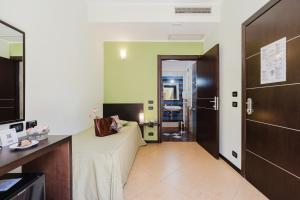 a hotel room with a bed and a door at Cerri Hotel in Castellammare del Golfo