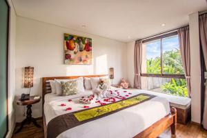 a bedroom with a large bed with roses on it at Kamajaya Villas in Ubud +25 photos