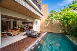a backyard with a swimming pool and a house at Kamajaya Villas in Ubud