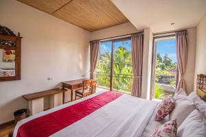 a bedroom with a bed and a large window at Kamajaya Villas in Ubud