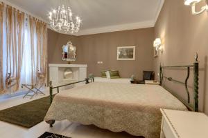 1 dormitorio con 1 cama con chimenea y lámpara de araña en Florence Apartments, Home Feeling, en Florencia