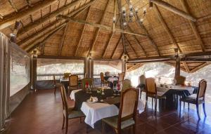 a dining room with tables and chairs and a ceiling at Sable Ranch Bush Lodge in Brits
