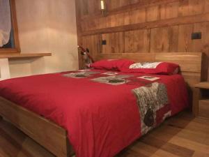 a bedroom with a large bed with a red blanket at Lo Péyo Avise in Avise