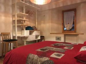 a bedroom with a bed with a red blanket at Lo Péyo Avise in Avise