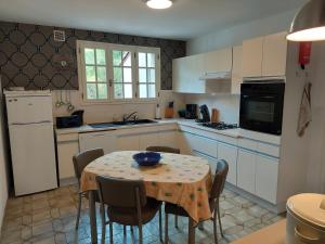 a kitchen with a table with chairs and a table and a table at Maison Lavande in Sousceyrac