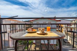 a table with a plate of food on a balcony at B&B Cardedu in Cardedu