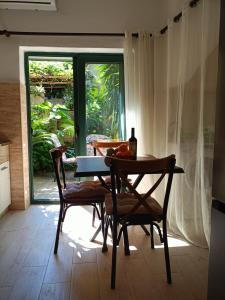 a dining room with a table and chairs and a window at Studio Apartman GRACIJA in Herceg-Novi