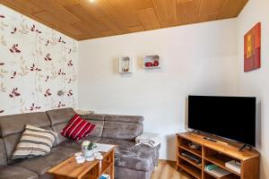 a living room with a couch and a flat screen tv at Ferienwohnung Henrich in Hooksiel
