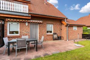 a patio with a table and chairs in front of a house at Ferienwohnung Henrich in Hooksiel