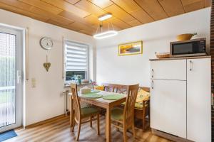a kitchen and dining room with a table and a refrigerator at Ferienwohnung Henrich in Hooksiel +16 photos