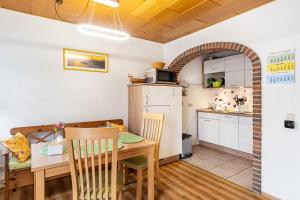 a kitchen and dining room with a wooden table and a kitchen with a tablektop at Ferienwohnung Henrich in Hooksiel