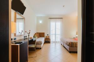 a hotel room with a bed and a desk and a sink at Cerri Hotel in Castellammare del Golfo