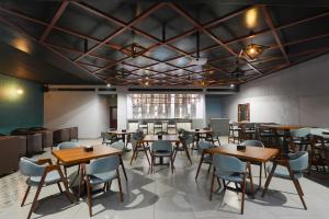 a dining room with wooden tables and chairs at Clay House in Trichūr
