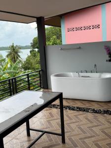 a bathroom with a bath tub and a table at Leam Sai Seaview in Ban Laem Sai +154 photos