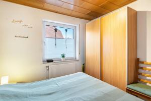 a bedroom with a bed and a window at Ferienwohnung Henrich in Hooksiel