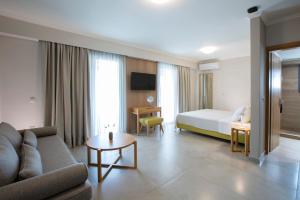 a hotel room with a couch and a bed and a table at Zisis Suites in Nydri +42 photos