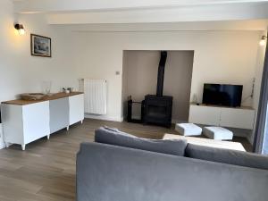 a living room with a couch and a tv at Gite Baie 3km plages in Telgruc-sur-Mer