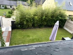 a patio with an umbrella on a lawn at Gite Baie 3km plages in Telgruc-sur-Mer