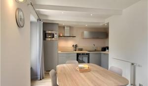 a kitchen with a wooden table and chairs in a room at Gite Baie 3km plages in Telgruc-sur-Mer