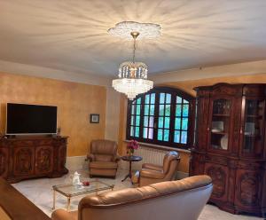 a living room with a couch and a tv and a chandelier at Villa Felicità in Lucca