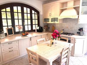 a kitchen with a table with a vase of flowers on it at Villa Felicità in Lucca