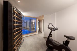 a gym with a treadmill and a room with a swimming pool at Chalet Banja in Zermatt