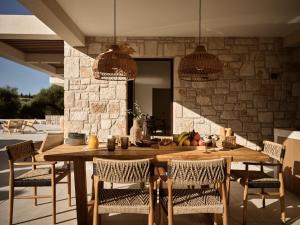 a dining room with a wooden table and chairs at Alba d'Oro in Laganas