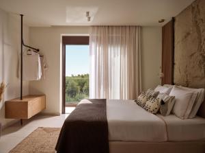 a bedroom with a large bed with a large window at Alba d'Oro in Laganas +57 photos