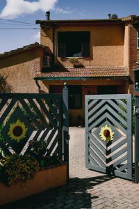 a white gate in front of a house at "IL CASALE DEI GIRASOLI" Country House in Capalbio in Capalbio +125 photos