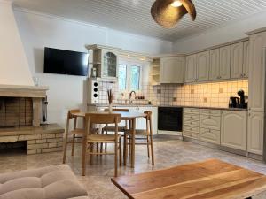 a kitchen with white cabinets and a table and chairs at Villa Delphini in Argyrátika