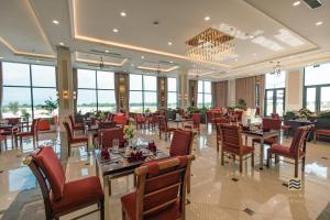 a restaurant with tables and chairs and a chandelier at Golden Sands Golf Resort in Hue