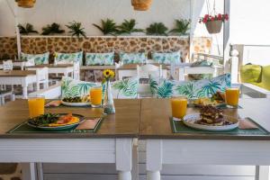 a table with two plates of food and orange juice at Bay's in Spetses