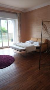 a bedroom with a bed and a wooden floor at La vie en couleur in Clohars-Carnoët