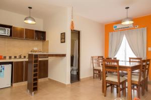 cocina y comedor con mesa y sillas en Las Tulmas Apartamentos Salta en Salta