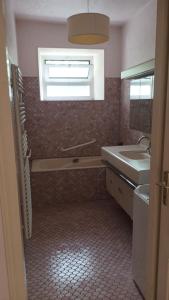 a bathroom with a sink and a window at La vie en couleur in Clohars-Carnoët