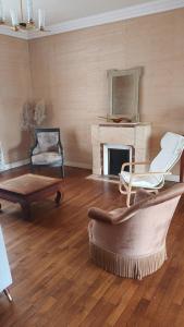 a living room with a couch and a chair and a fireplace at La vie en couleur in Clohars-Carnoët