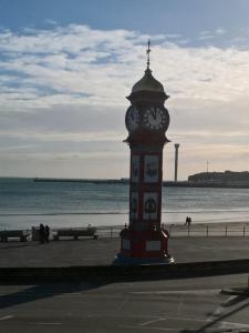 a clock tower in front of the beach at The Leam Hotel in Weymouth