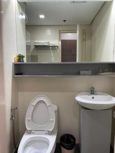 a bathroom with a toilet and a sink and a mirror at Comfy condo convenient location in Iloilo City +8 photos