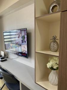 a room with a desk with a tv on a wall at Comfy condo convenient location in Iloilo City