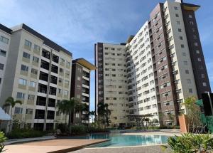 two tall buildings with a pool in front of them at Comfy condo convenient location in Iloilo City