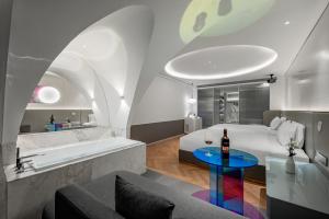 a bathroom with a tub and a bed and a table at Aspera Star Essence Sky Garden Panoramic Hotel-Jiefangbei Hongya Branch in Chongqing +55 photos